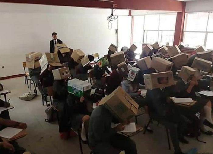 Учитель на экзамене надевает своим ученикам коробки на головы, чтобы они не списывали