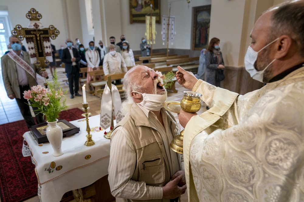 В масках, перчатках, а порой и в защитных комбинезонах: украинские священники вернулись к своим обязанностям
